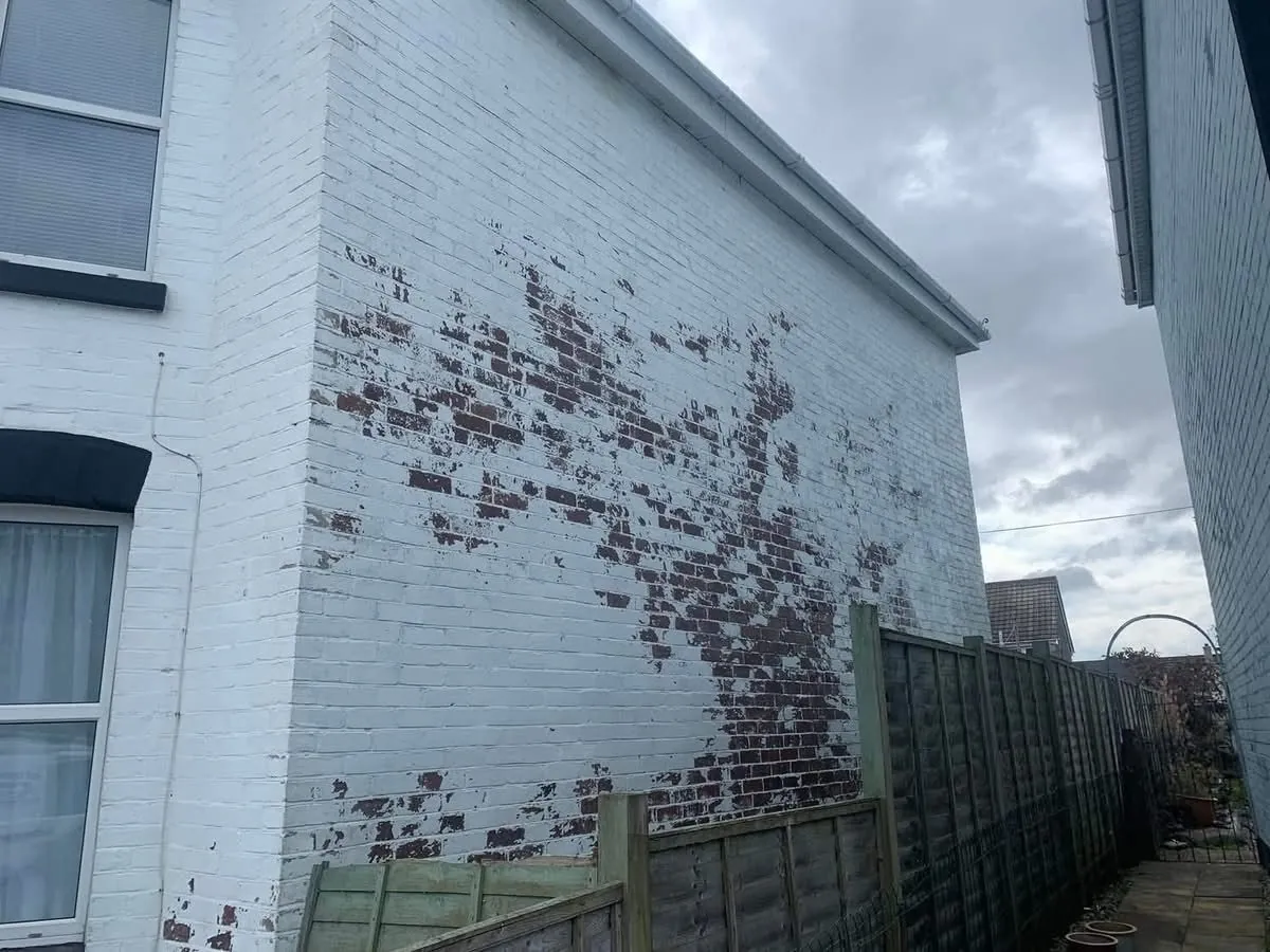 Peeling paint on a brick wall before redecoration in South Molton